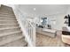 Open-concept living room with staircase, modern furniture, and a view of the kitchen at 12541 Lylan Ridge St, Las Vegas, NV 89138