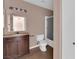 Bathroom featuring dark vanity, mirror, toilet, and shower-tub combo with sliding door at 1541 Linnbaker Ln # 202, Las Vegas, NV 89110