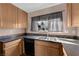 Close up on stainless steel sink and wood cabinets and counter with tile backsplash at 1541 Linnbaker Ln # 202, Las Vegas, NV 89110