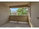 A neutral toned patio with view of nearby roof and lush green tree at 1541 Linnbaker Ln # 202, Las Vegas, NV 89110