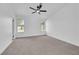 Bright bedroom features neutral carpet, ceiling fan, and white walls with natural light from two windows at 1905 Joella St, Las Vegas, NV 89108