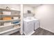 Well-lit laundry room featuring modern washer and dryer, built-in shelves, and dark laminate flooring at 192 Biscotti Ave # Lot 120, North Las Vegas, NV 89084