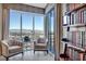 Bright living room with floor to ceiling windows providing stunning city views and filled bookcase at 200 W Sahara Ave # 1711, Las Vegas, NV 89102