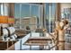 Bright living room with floor to ceiling windows providing stunning city views and filled bookcase at 200 W Sahara Ave # 1711, Las Vegas, NV 89102