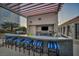 Outdoor kitchen bar area with marble counter, steel appliances, and blue striped stools at 200 W Sahara Ave # 1711, Las Vegas, NV 89102