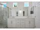 Bright bathroom with dual sinks, quartz counters, glass shower, and mirrors at 2265 Lauren Dr, Las Vegas, NV 89134