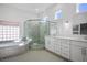 Bright bathroom featuring a glass enclosed shower, soaking tub and double sink vanity at 2265 Lauren Dr, Las Vegas, NV 89134