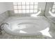 Close up of bright white soaking tub with jets and mosaic tile surround at 2265 Lauren Dr, Las Vegas, NV 89134