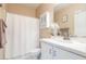 Bright bathroom with a white vanity, decorative mirror and a shower with a curtain at 2392 Mystic Star St, Henderson, NV 89044