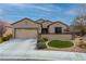 Attractive home exterior with a two-car garage, mature landscaping, and stone accents at 2392 Mystic Star St, Henderson, NV 89044