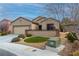 Attractive home exterior with a two-car garage, mature landscaping, and stone accents at 2392 Mystic Star St, Henderson, NV 89044