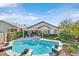 Lush backyard showcasing a pristine pool, jacuzzi, pergola, and verdant landscaping, an ideal oasis at 2597 Belgreen St, Las Vegas, NV 89135