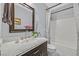 Well-lit bathroom featuring a marble countertop vanity and shower with patterned curtains at 2597 Belgreen St, Las Vegas, NV 89135