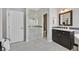 Bright bathroom featuring a glass shower, marble floors, and dark wood cabinets at 2597 Belgreen St, Las Vegas, NV 89135