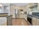 Modern kitchen featuring stainless steel appliances, mosaic backsplash, and wood-look tile flooring at 2597 Belgreen St, Las Vegas, NV 89135