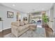 Bright living room with a large sectional sofa, view to the backyard patio, and wood floors at 2597 Belgreen St, Las Vegas, NV 89135