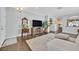 Cozy living room with hardwood floors, comfortable seating, and a view into the kitchen and dining areas at 2597 Belgreen St, Las Vegas, NV 89135