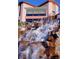 Exterior shot of a building featuring a striking rock waterfall and large windows for natural lighting at 2921 Hayden Creek Ter, Henderson, NV 89052