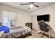 Comfortable bedroom with wood floor, gaming chair, window, and dark ceiling fan at 321 Agora Way, Las Vegas, NV 89110