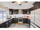 Modern kitchen featuring dark cabinetry, granite countertops, stainless steel appliances and decorative backsplash at 321 Agora Way, Las Vegas, NV 89110