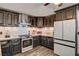 A cozy kitchen with dark cabinets, modern appliances, and white subway tile backsplash at 321 Agora Way, Las Vegas, NV 89110