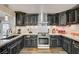 A well-lit kitchen equipped with dark cabinetry, granite countertops, and a stainless steel oven at 321 Agora Way, Las Vegas, NV 89110