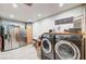 Functional laundry room equipped with a washer, dryer, stainless refrigerator, and ample storage at 321 Agora Way, Las Vegas, NV 89110