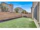 Spacious backyard with faux grass, retaining wall, string lights, and seating area at 382 Gracious Way, Henderson, NV 89011