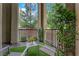 Relaxing balcony area featuring two chairs, a small table, artificial turf, and views of the greenery at 41 Via Verso Lago, Henderson, NV 89011