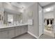 Bright bathroom with double vanity, soft gray cabinetry, and walk-in closet access at 41 Via Verso Lago, Henderson, NV 89011