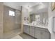 Modern bathroom showcasing a glass enclosed shower, dual sinks, and tiled floors at 41 Via Verso Lago, Henderson, NV 89011