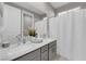 Bathroom featuring double sinks with counter space, a mirror, and a shower with a white curtain at 41 Via Verso Lago, Henderson, NV 89011