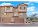 Inviting townhome featuring multiple garage doors, brick accents, and well-maintained landscaping at 41 Via Verso Lago, Henderson, NV 89011