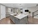 Spacious kitchen featuring a large island, modern appliances, gray cabinets, and hardwood flooring at 41 Via Verso Lago, Henderson, NV 89011