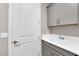 Practical laundry area with a utility sink, gray cabinets, and door at 41 Via Verso Lago, Henderson, NV 89011