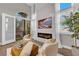 Bright living room with fireplace, white chairs, large windows, and access to the outdoor balcony at 41 Via Verso Lago, Henderson, NV 89011