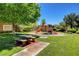 Community playground with picnic tables, a play structure, and mature trees in a well-maintained green space at 420 Blush Creek Pl, Las Vegas, NV 89144