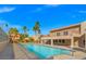 Gorgeous pool with a balcony, a lounge, palm trees, and a bright blue sky in the background at 5060 Indian River Dr # 382, Las Vegas, NV 89103