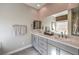 Bathroom featuring double vanity sinks, quartz counters, and a framed mirror at 510 Copper Falcon Ave, Henderson, NV 89011