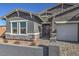 A close-up of a grey single-story home with stone accents and manicured landscaping leading to a paved driveway at 510 Copper Falcon Ave, Henderson, NV 89011