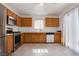 Well-lit kitchen with wooden cabinets, stainless steel appliances, and tile flooring creates a clean and functional cooking space at 5541 Ramirez St, North Las Vegas, NV 89031