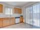 Kitchen features wood cabinets, tile flooring, and a sliding glass door for backyard access and an abundance of natural light at 5541 Ramirez St, North Las Vegas, NV 89031