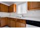 Clean kitchen featuring wood cabinets, a stainless steel sink, and white countertops provides a functional space for meal preparation at 5541 Ramirez St, North Las Vegas, NV 89031