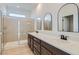 Spacious bathroom with double sinks, stylish mirrors, and a glass-enclosed shower at 5606 Spring Trellis St, Las Vegas, NV 89113