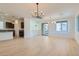 Open-concept living room with hardwood floors, modern lighting, and seamless flow to the kitchen at 5606 Spring Trellis St, Las Vegas, NV 89113