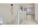 Modern stairway with white railings, wood floors and decorative pendant lighting at 5606 Spring Trellis St, Las Vegas, NV 89113