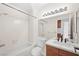 Bathroom featuring a shower-tub combo, wood cabinets, and marble countertop at 6130 Desert Sun Dr, Las Vegas, NV 89110