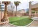 Backyard featuring artificial grass, tall palm trees, and a brick border at 6938 Silk Oak Ct, Las Vegas, NV 89148