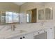 Bright bathroom features a dual sink vanity with a marble countertop, and lots of natural light at 6938 Silk Oak Ct, Las Vegas, NV 89148