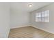 Bright and empty bedroom with wood-look flooring and a window overlooking the neighborhood at 6938 Silk Oak Ct, Las Vegas, NV 89148